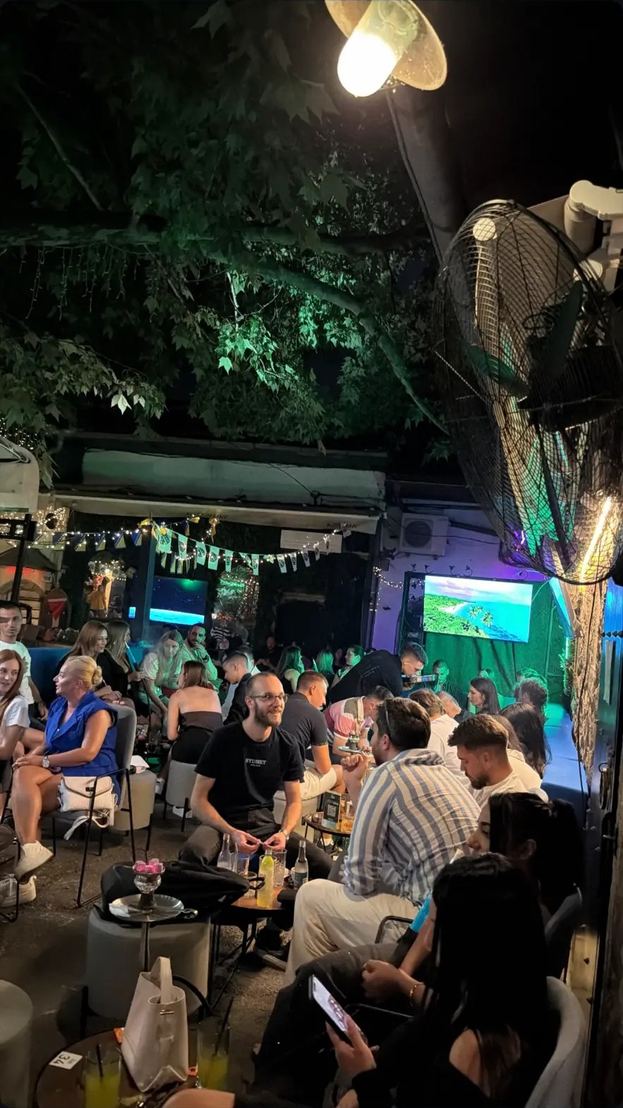 Open-air garden lounge with string lights at dusk