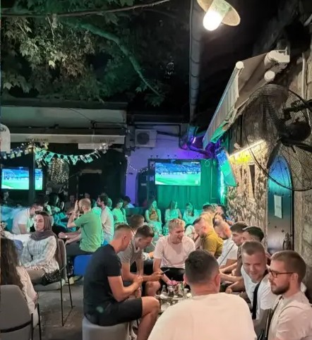 Evening crowd enjoying shisha under string lights