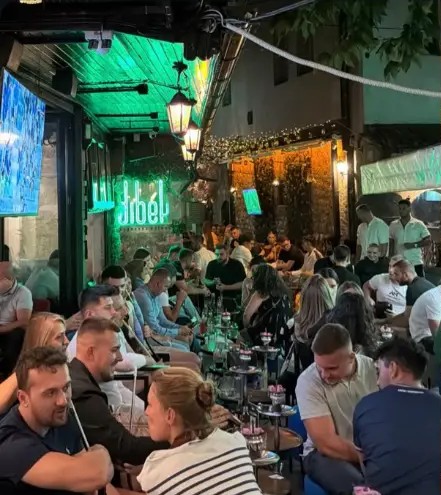 Guests relaxing under the neon Dibek sign