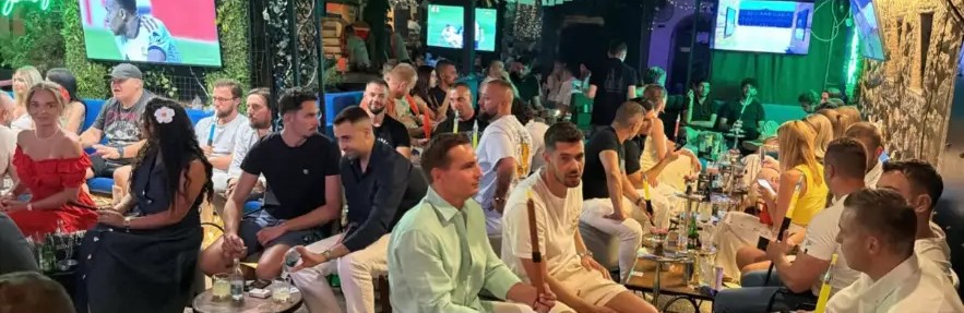 Blue sofas filled with guests and hookahs